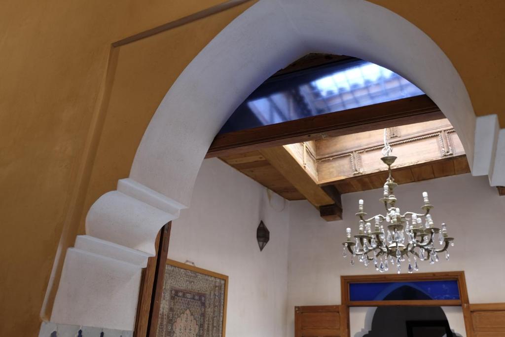 um candelabro pendurado num tecto num quarto em Dar Jameel em Fez