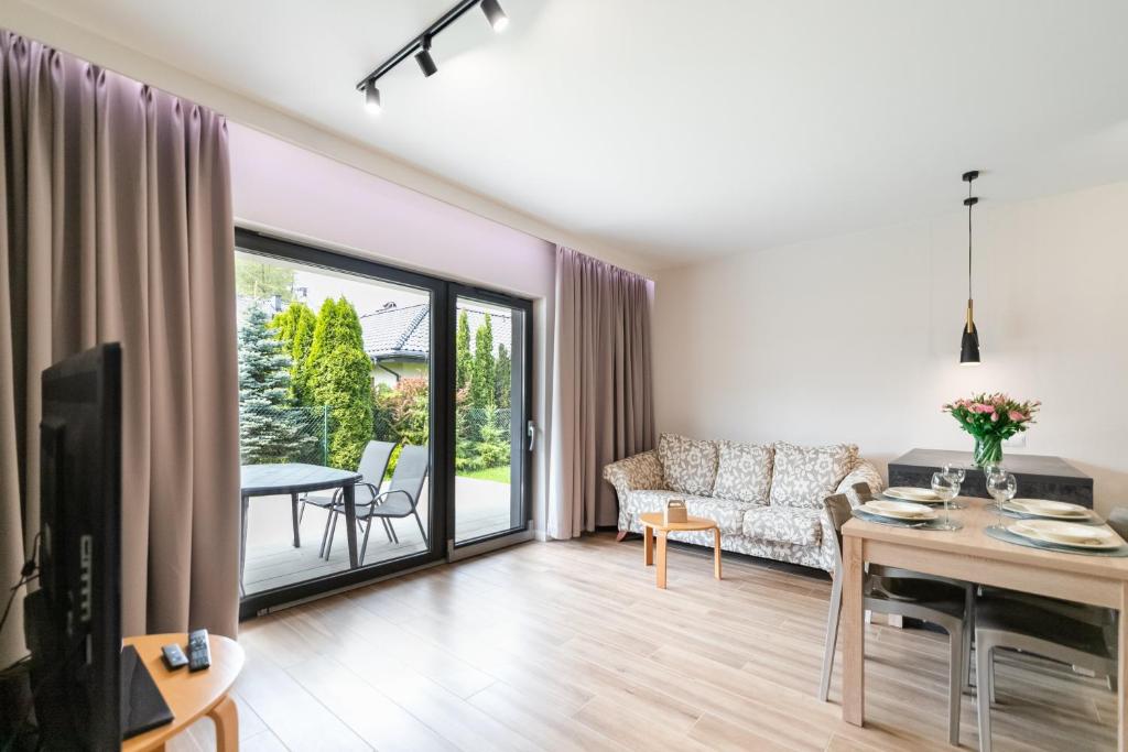 a living room with a couch and a table at Apartament Kochanowskiego z ogródkiem i garażem - Dream Apart in Ustroń