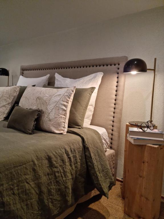 a bedroom with a bed with a lamp and pillows at B&B à la campagne in Jayat