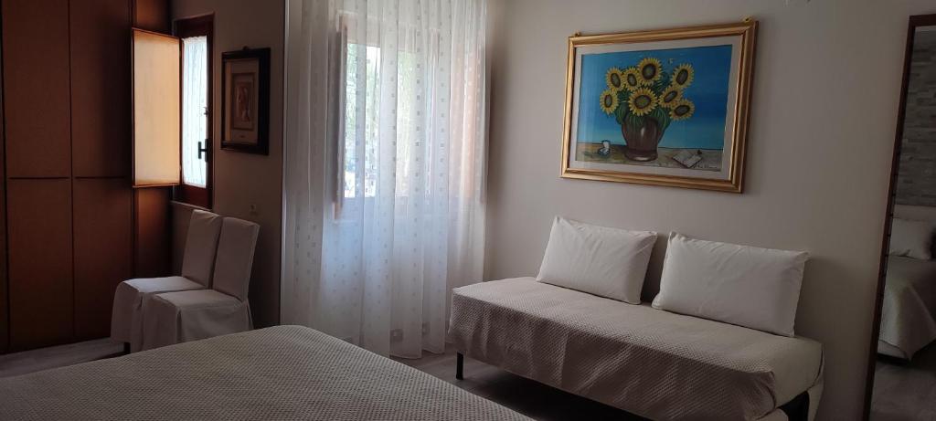 Zimmer mit einem Bett, einem Stuhl und einem Fenster in der Unterkunft Dimora Il Tulipano in Vieste