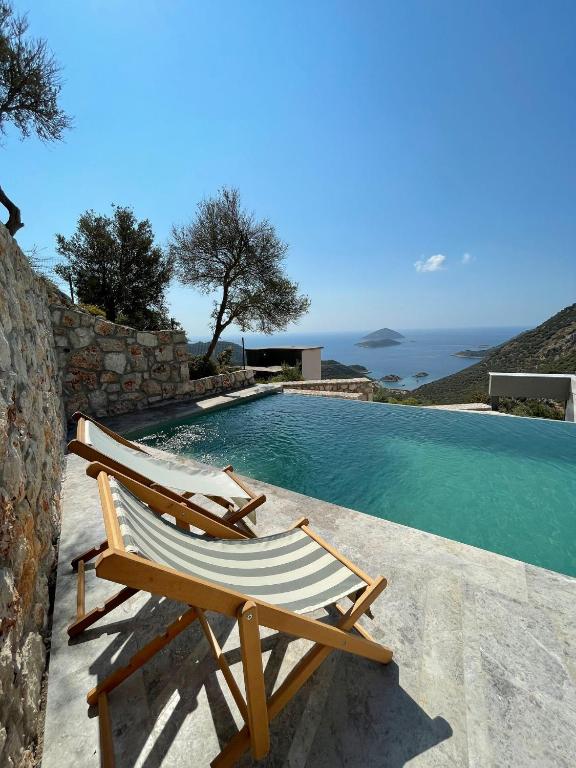 a pair of chairs sitting next to a swimming pool at Notos Club in Kaş
