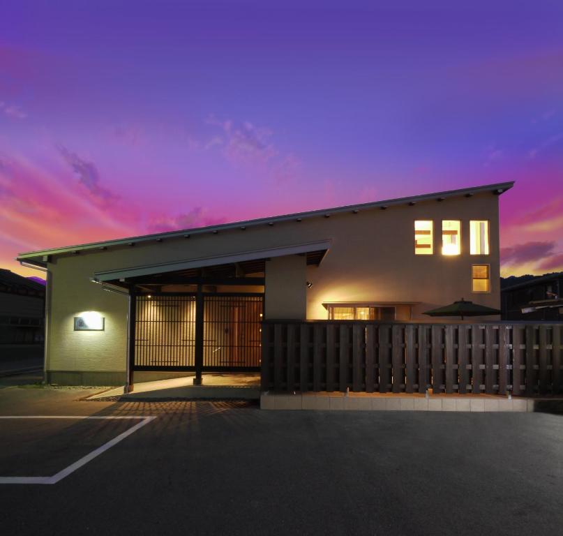 un bâtiment avec un coucher de soleil en arrière-plan dans l'établissement villa-rizo - Vacation STAY 13184, à Hida