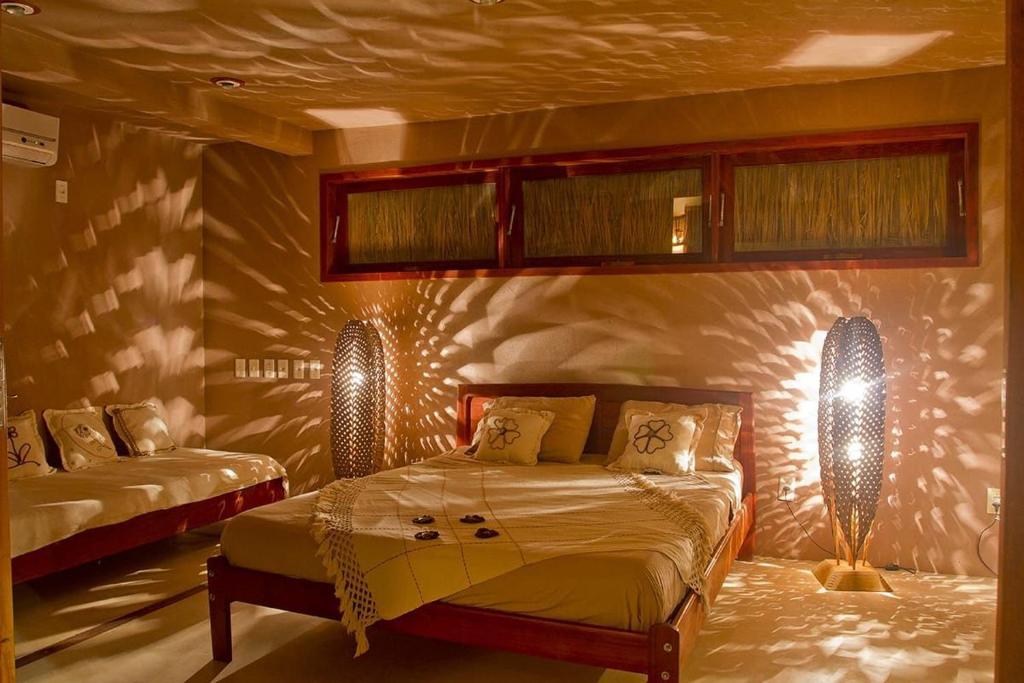 sypialnia z 2 łóżkami z oświetleniem na ścianie w obiekcie KazaBrasil w mieście Icaraí
