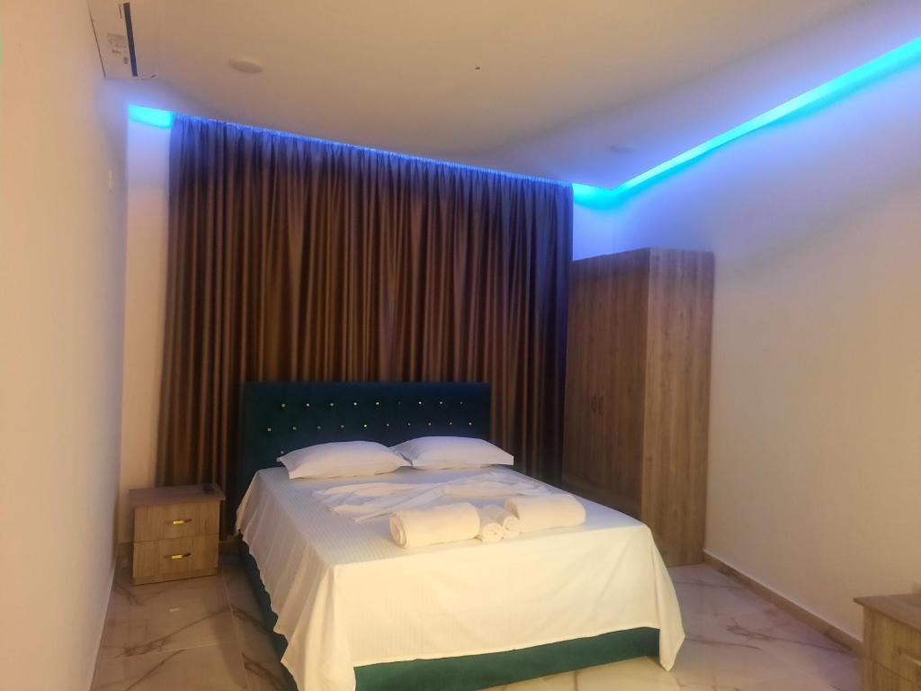 um quarto com uma cama com luzes azuis em HOTEL MEGNIAR em Lushnjë