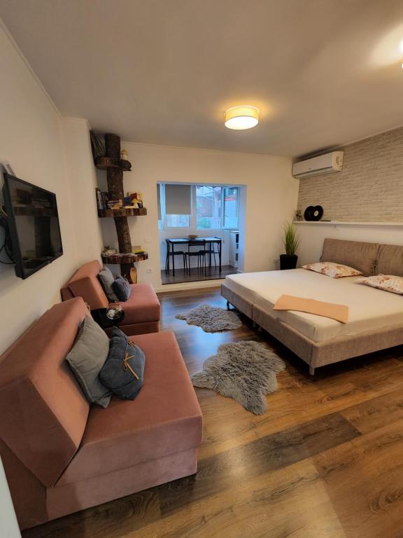 a living room with a bed and a couch at TRAVELER'S PLACE at Tirana City Centre in Tirana