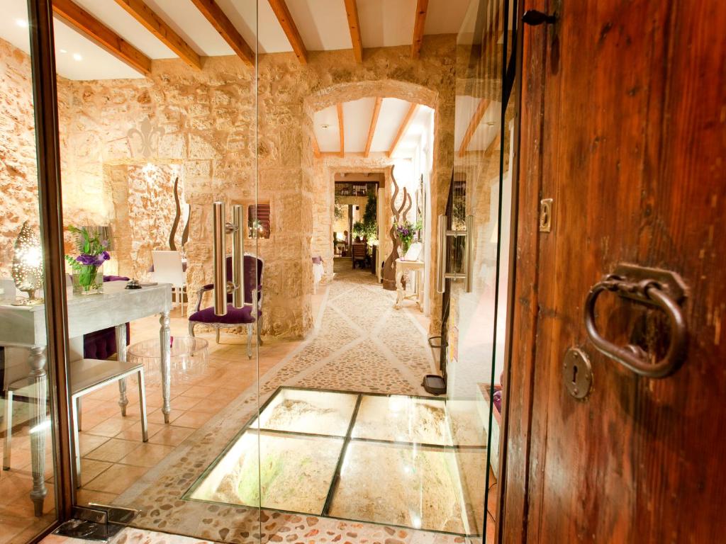 um corredor com uma porta de vidro e um quarto com uma mesa em Ca´n Pere na Alcúdia