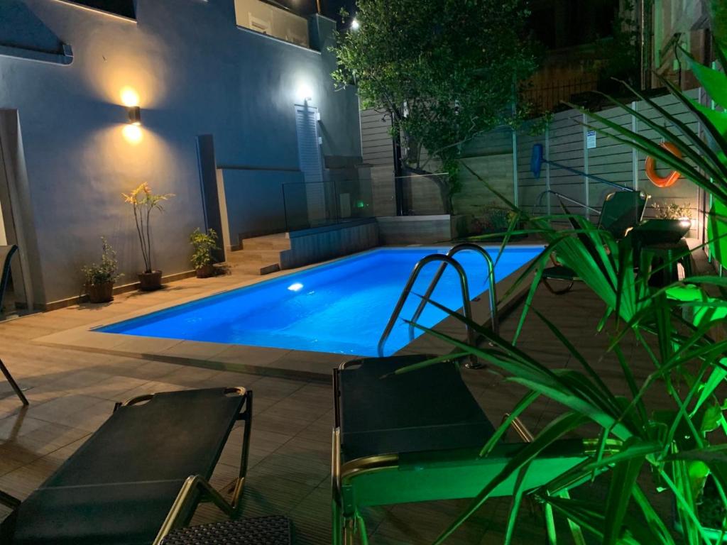a large blue swimming pool in a yard at night at Vista Magica in Chania Town