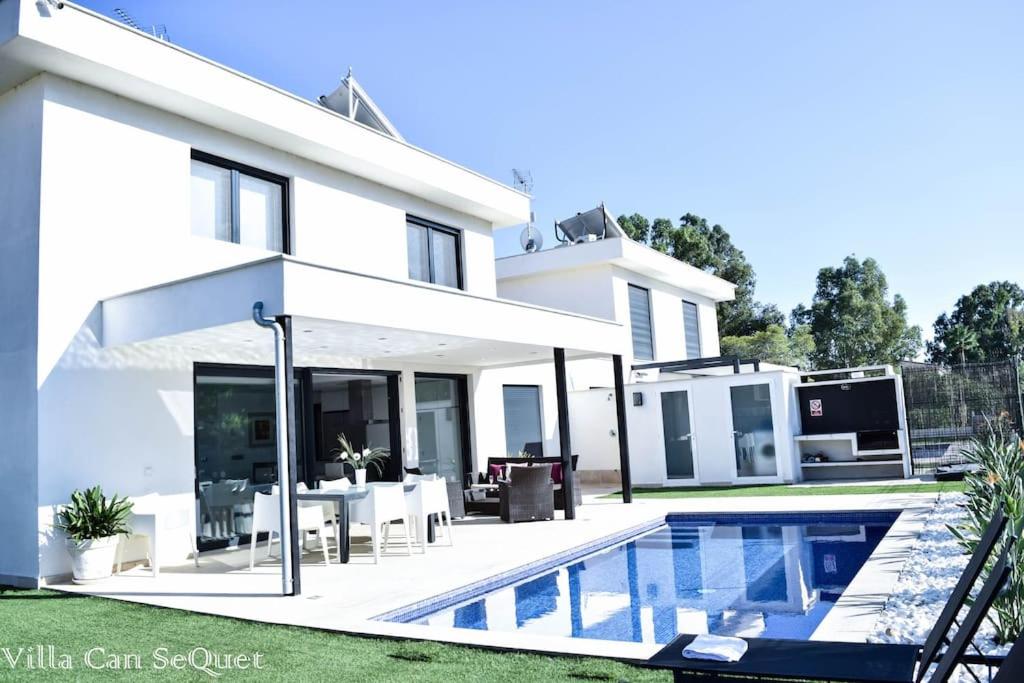 una casa blanca con piscina frente a ella en Villa Can SeQuet (Playa de Muro) en Muro