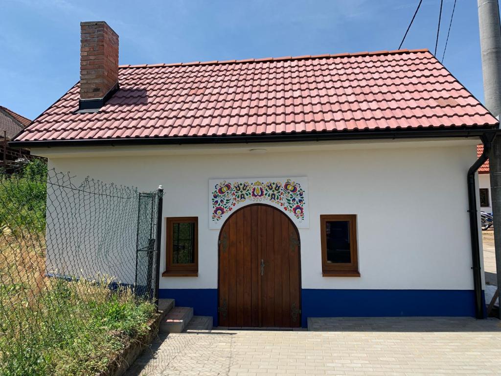 una pequeña casa blanca con puerta marrón en Vinný sklep S&T Výmola, en Mikulčice