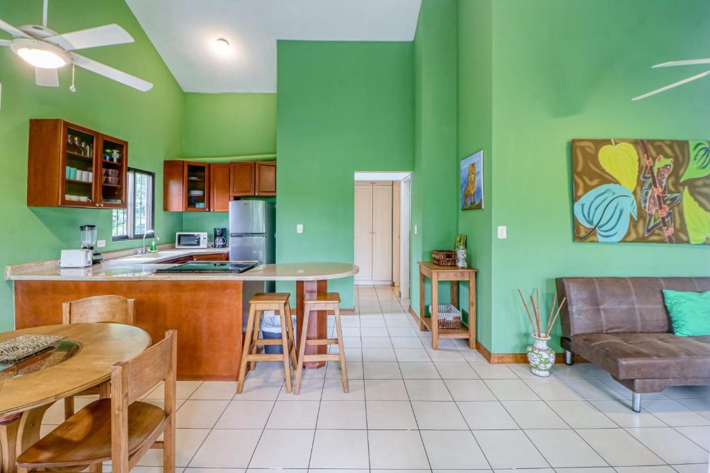 cocina y sala de estar con paredes verdes en Dulce La Colina 8002, en Coco