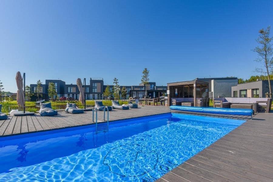 a swimming pool with blue water in a building at Apartamentai AQUA in Palanga