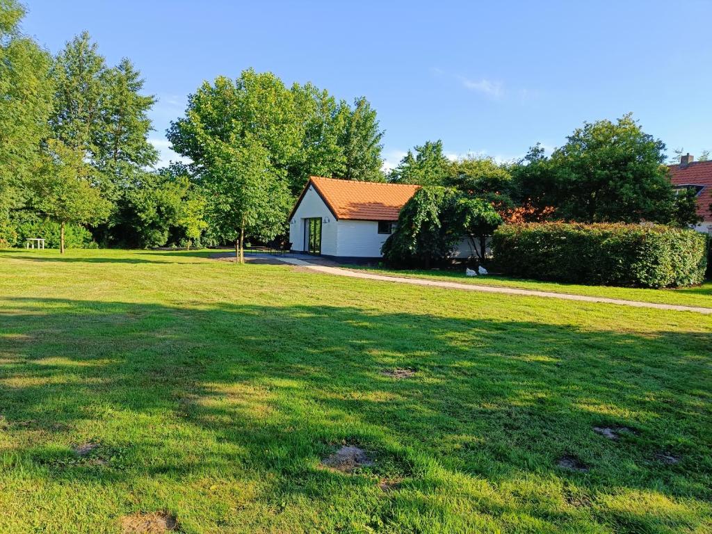 a house in the middle of a grass field at Natuurlijk leuk in Sterksel