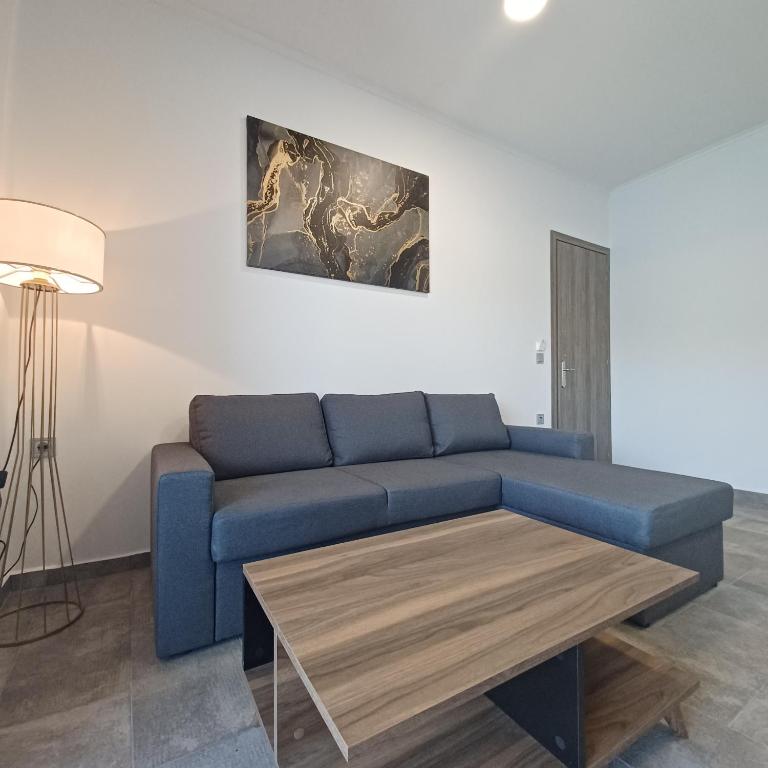a living room with a blue couch and a coffee table at Ponti Bay Apartments in Vasiliki
