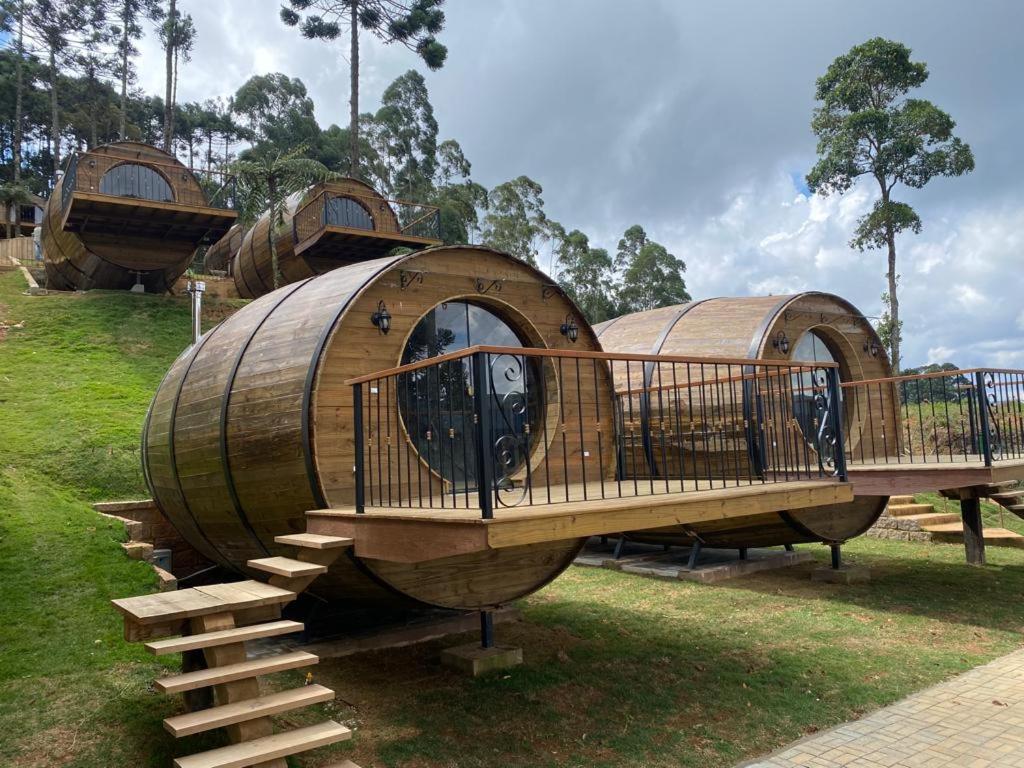 a group of three circular wooden domes in a park at Pousada Villa Barril in Monte Verde