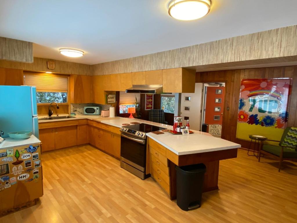 een keuken met houten vloeren en een fornuis met oven bij All the Waters Retro Home on Lake Michigan- Your Own PRIVATE BEACH in Benton Harbor
