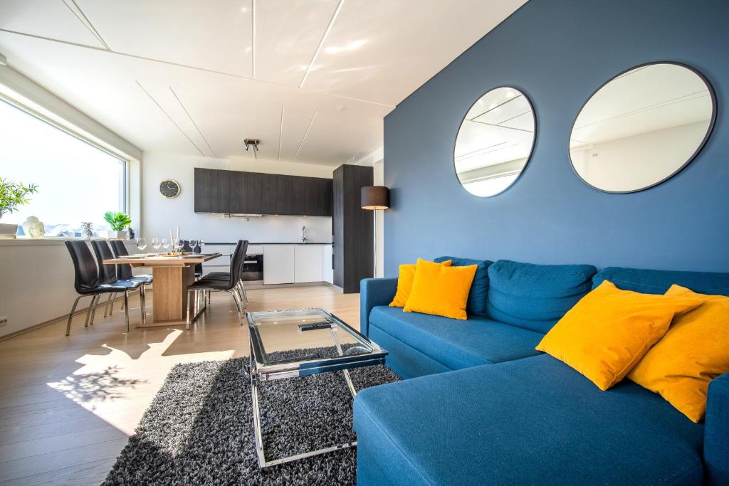 salon z niebieską kanapą i stołem w obiekcie Arctic Homes - Premium Tromsø Residence w mieście Tromsø
