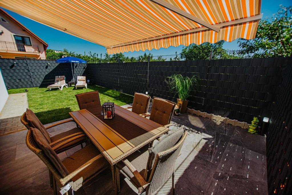 eine Terrasse mit einem Tisch, Stühlen und einem Sonnenschirm in der Unterkunft Ap.Casa la Neamtu in Sibiu