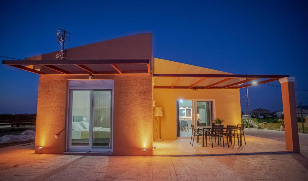 a building with a patio with a table and chairs at Augoustinos Luxury Villa in Sarakinádhon