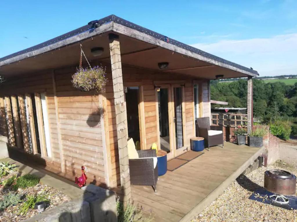 una pequeña casa de madera con terraza en Peaceful Cabin Retreat in Skegby, en Sutton-in-Ashfield