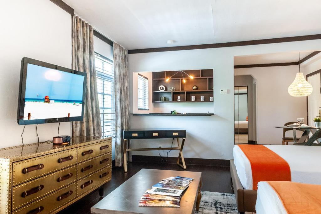a hotel room with a bed and a flat screen tv at Lincoln Arms Suites in Miami Beach