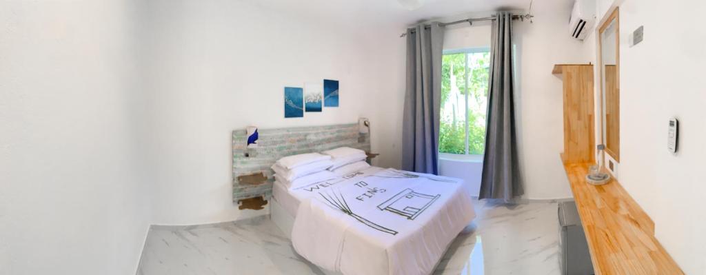 - une chambre avec 2 lits dans une chambre avec une fenêtre dans l'établissement Fins Dive and Leisure Hotel, à Rasdhoo