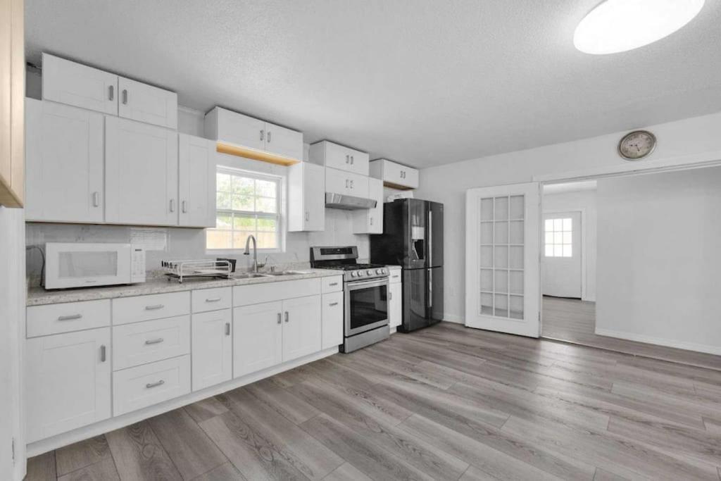 a kitchen with white cabinets and a wooden floor at Near Fort Walton Beach, peaceful 5 bedrooms house in Fort Walton Beach