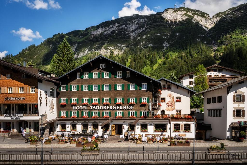eine Gruppe von Gebäuden vor einem Berg in der Unterkunft Hotel Tannbergerhof im Zentrum von Lech in Lech am Arlberg