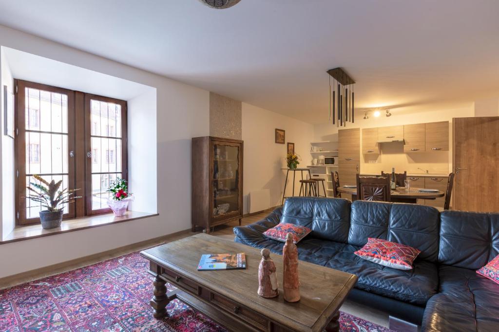 uma sala de estar com um sofá azul e uma mesa em LE RHENANUS Jacques Taurellus - appartement duplex au calme - centre ville - parking gratuit em Sélestat