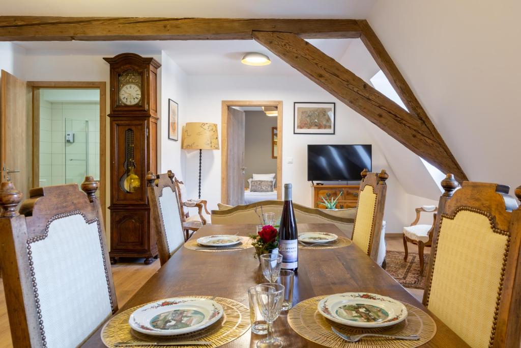 a dining room with a wooden table and chairs at LE RHENANUS Jean Geiler de Kaysersberg - appartement idéal pour famille, au calme - centre ville - parking gratuit in Sélestat