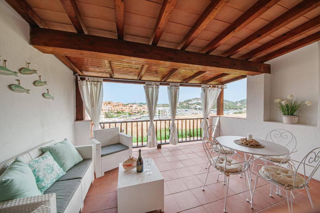 un soggiorno con un divano e un tavolo di [PORTO CERVO MARINA] Incantevole appartamento vista Yacht a Porto Cervo