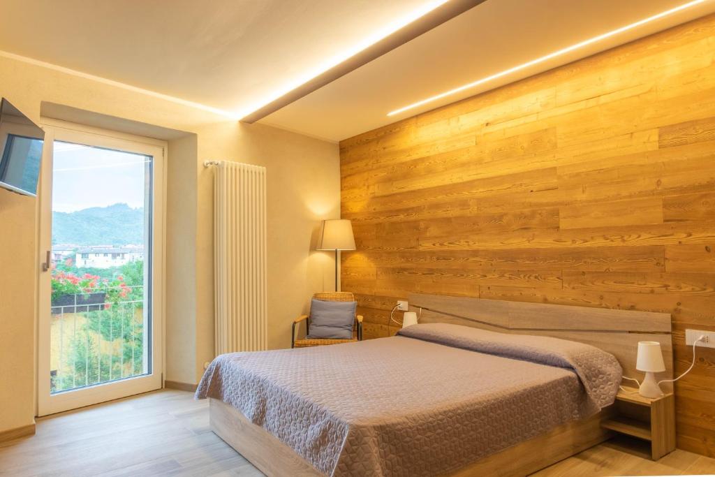 een slaapkamer met een bed en een groot raam bij Residenza LA RIVIERA in Dronero