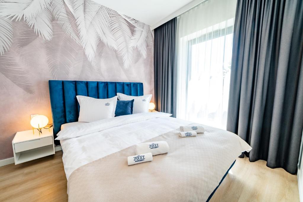 a bedroom with a large bed with two towels on it at Apartamenty w Zatoce in Mikołajki