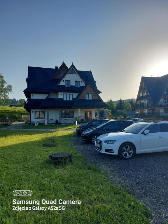 un grupo de autos estacionados frente a una casa en Dziadkowiec, en Białka Tatrzanska