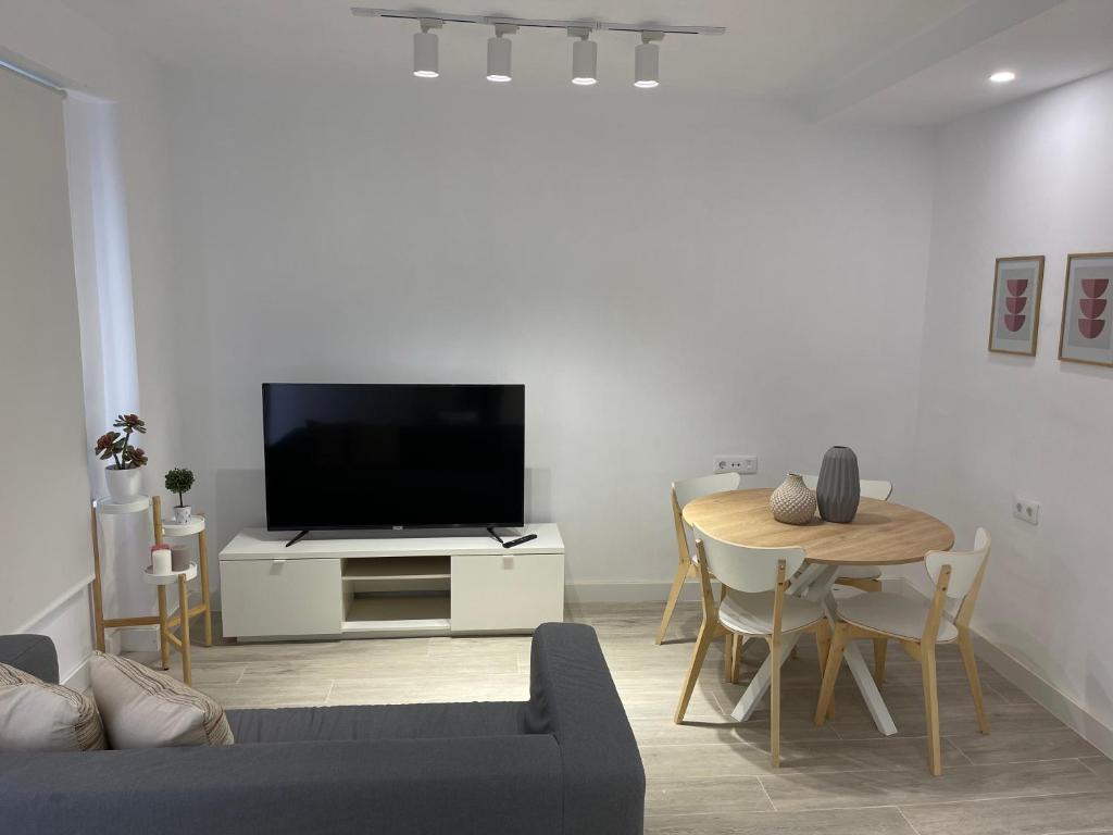 a living room with a tv and a table at Apartamento a 50 metros de la Plaza del Charco, Puerto de la Cruz in Puerto de la Cruz