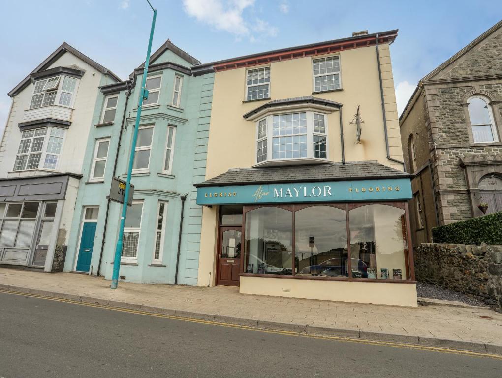 uma loja em frente a um edifício numa rua em Llety Ednyfed em Criccieth