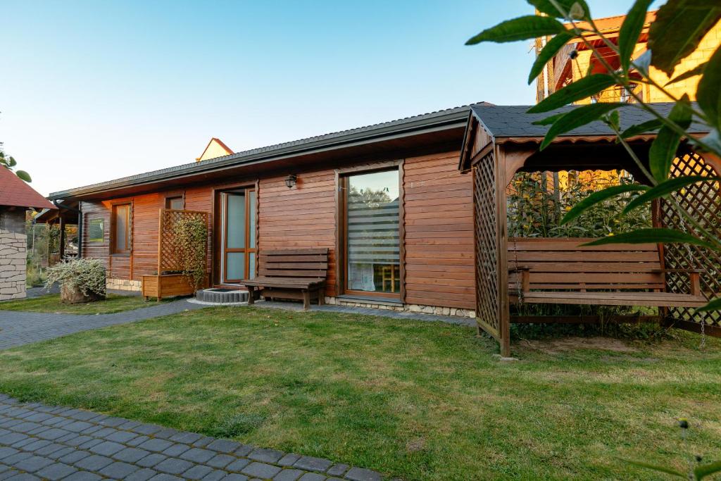 a house with a bench and a gazebo at Domek Rodzinny na Roztoczu in Nowiny