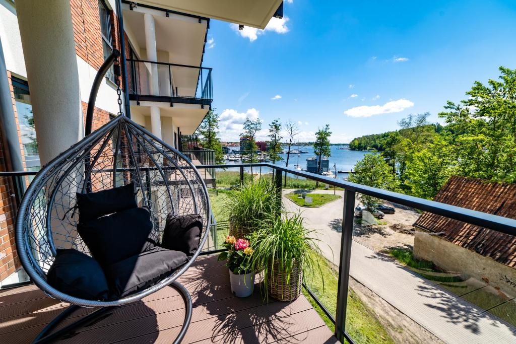 a swing on a balcony with a view of the water at Apartamenty w Zatoce in Mikołajki