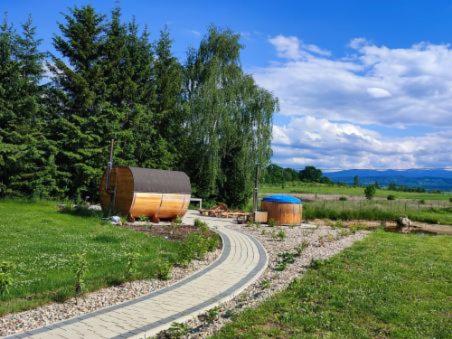 un camino sinuoso en un campo con un gran barril en Karkonosze, en Grudza