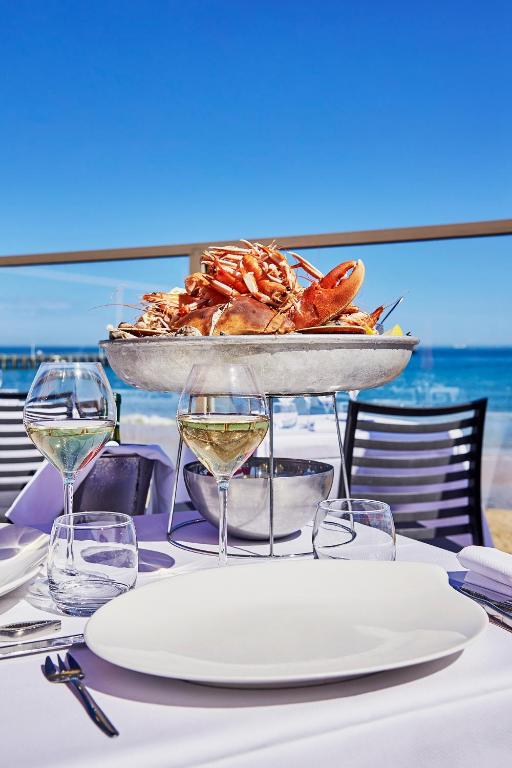 a table with a plate of seafood and glasses of wine at La Cremaillere Hôtel-Restaurant in Courseulles-sur-Mer