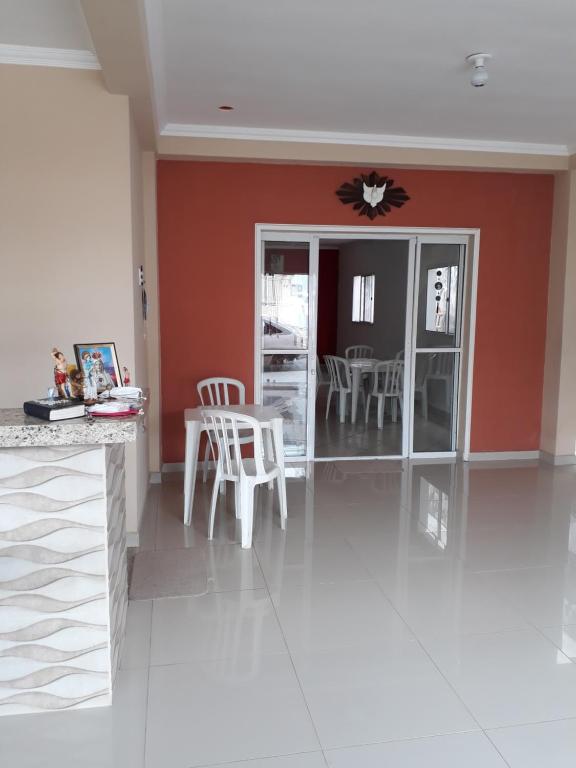 a kitchen with red walls and white tables and chairs at Pousada Frei Galvão in Cachoeira Paulista