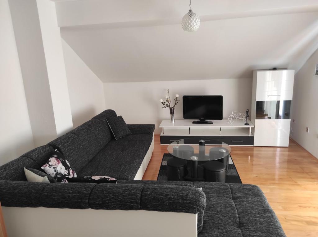 ein Wohnzimmer mit einem Sofa und einem Tisch in der Unterkunft Apartman Dario Livno in Livno