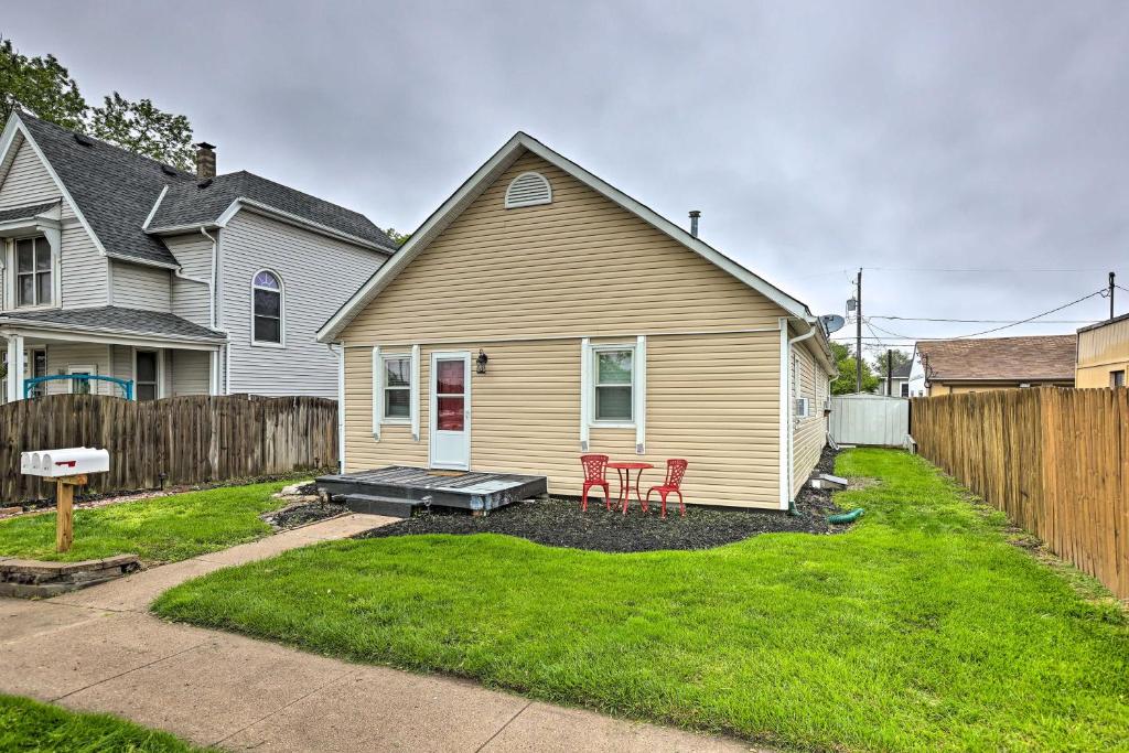 una casa con una sedia rossa nel cortile di Council Bluffs Cottage Proximity to Parks! a Council Bluffs