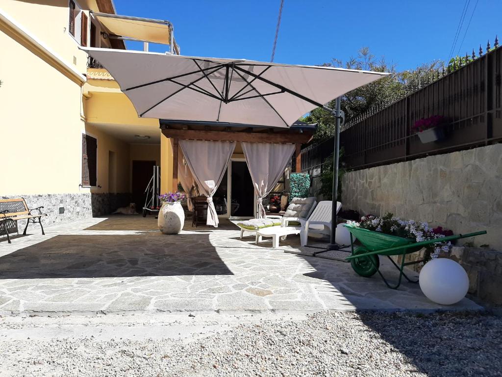 Casa Federica في Trinità: فناء فيه مظلة وطاولة وكراسي