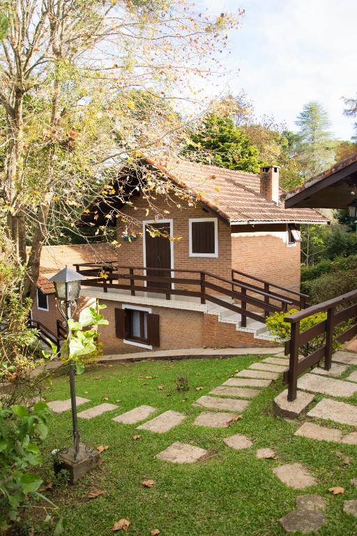a house with a fence and a yard with a house at Pousada Estrela da Serra in Monte Verde