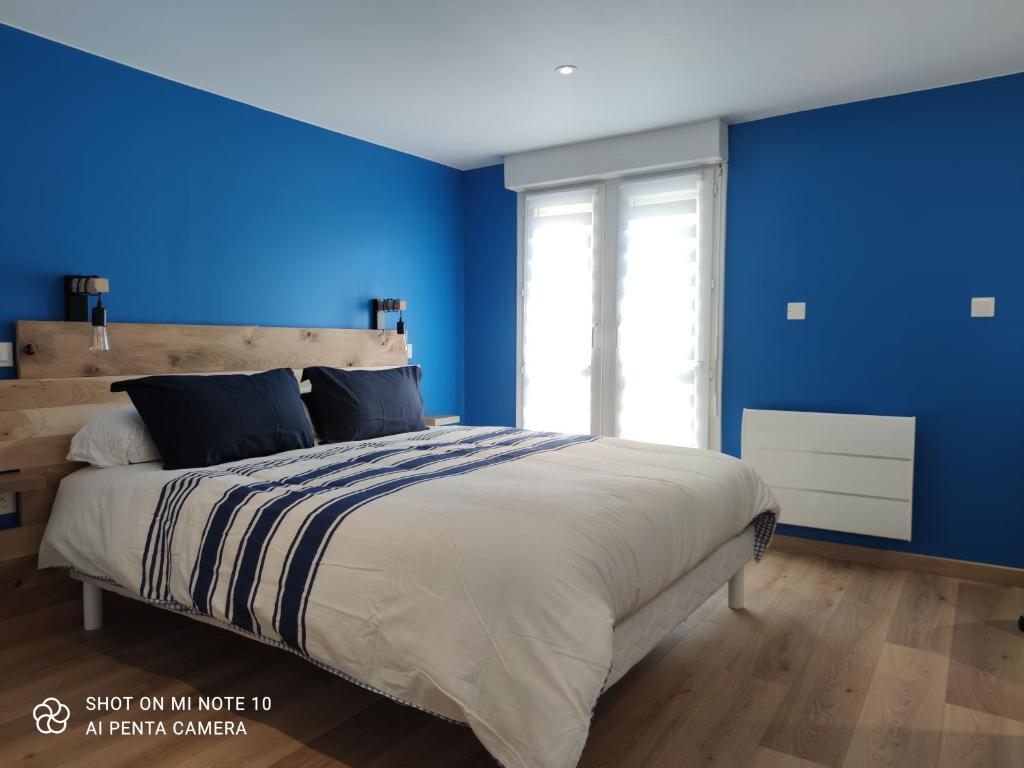 1 dormitorio con paredes azules y 1 cama grande en Appartement de charme en plein coeur de Bergerac, en Bergerac