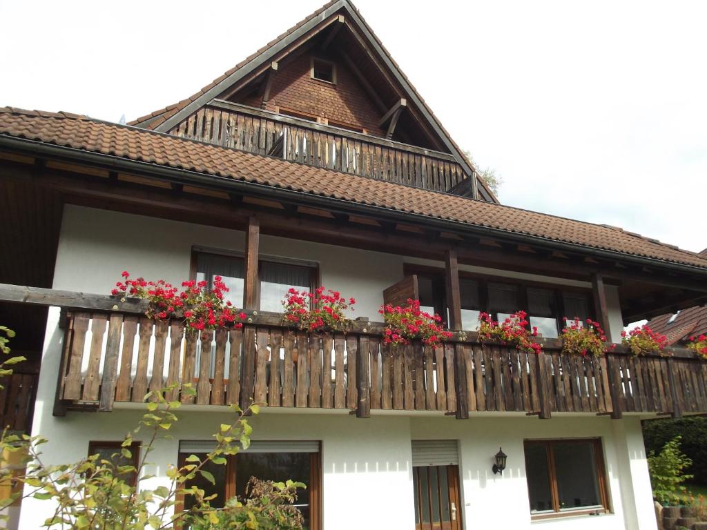 a house with a balcony with flowers on it at Pension Bergseeblick in Titisee-Neustadt