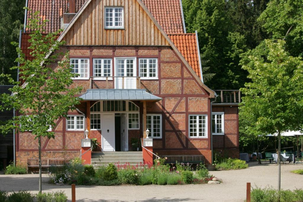 ein großes Backsteinhaus mit weißen Fenstern in der Unterkunft Hotel Waldhof auf Herrenland in Mölln