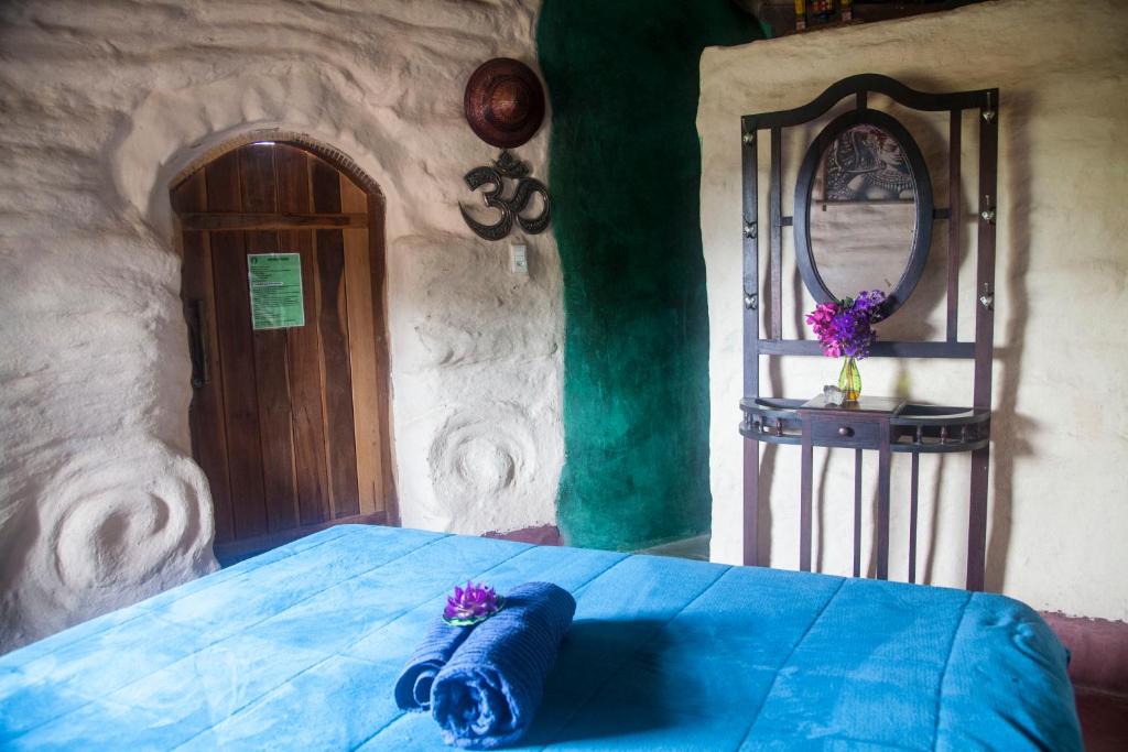 een slaapkamer met een blauw bed en een spiegel bij Sítio Monte Alegre in Ibicoara