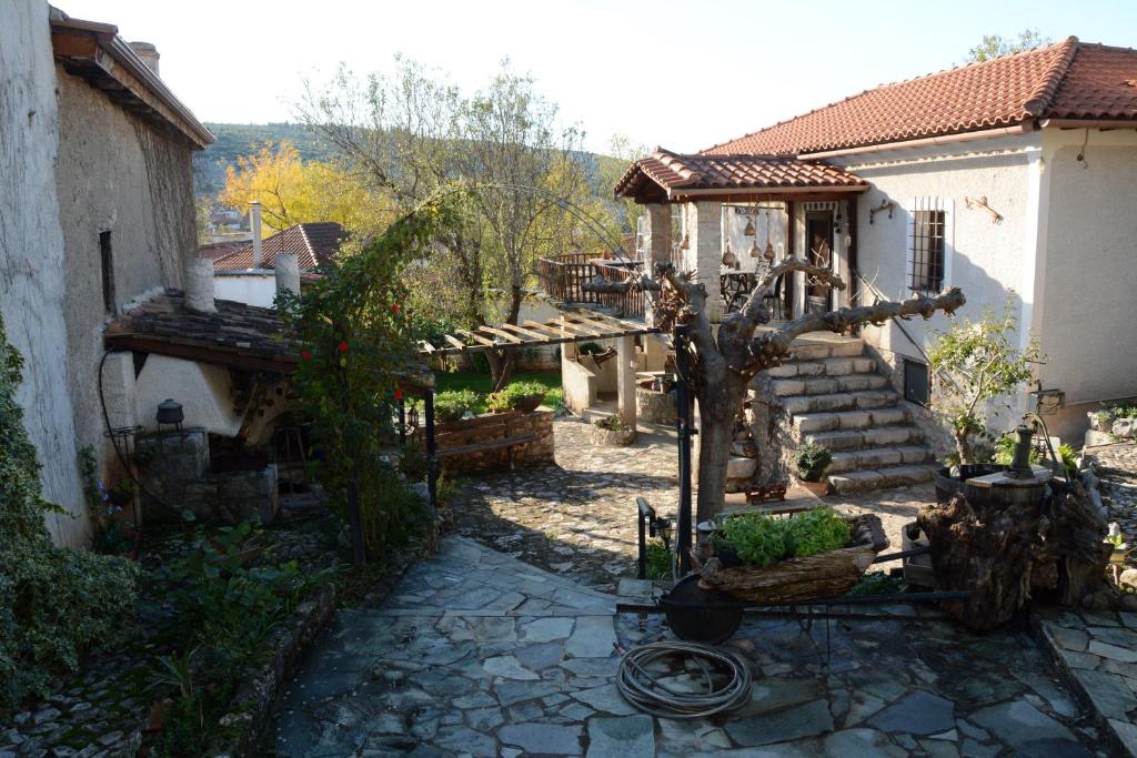 a small yard with a house and a tree at Giorgos' & Noula's Cottage in Desfina village- near Delphi in Dhesfína