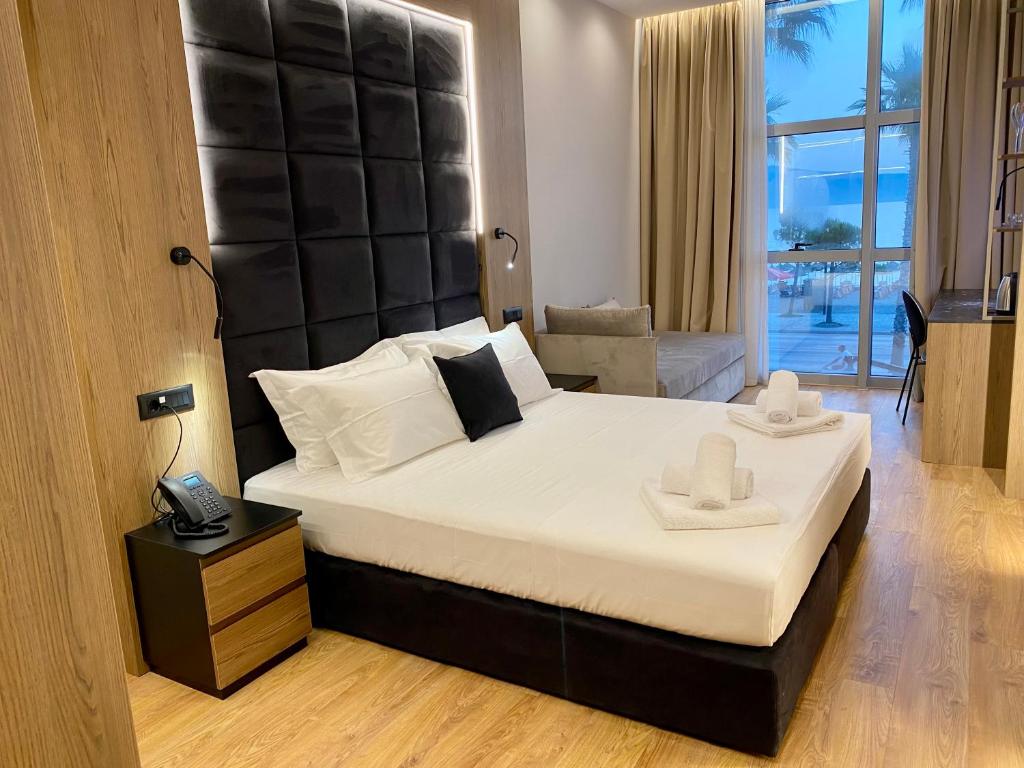 a bedroom with a large bed with a large headboard at ELMAR HOTEL in Vlorë